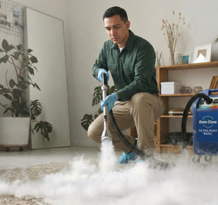 A person in protective gear disinfecting a carpet in a stylish living room, ensuring safety.